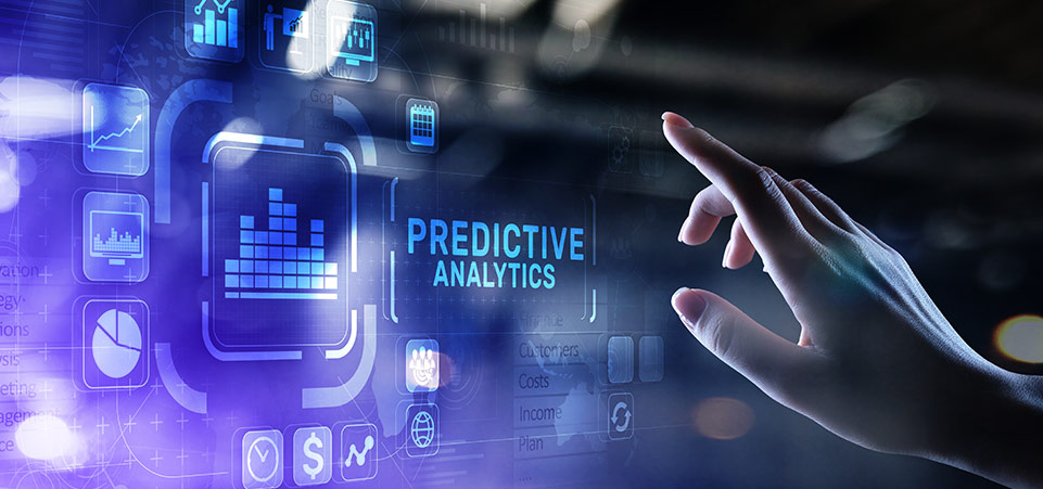 A hand in front of a smart surface that says predictive analytics and shows graphs and charts.