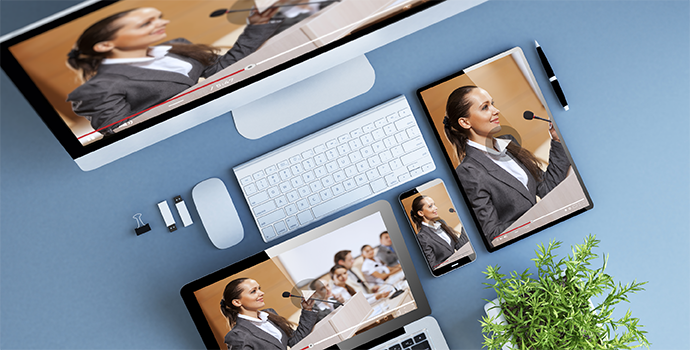 Multiple screens showing a live broadcast of a conference with a woman presenting in a panel.