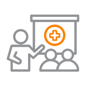 Icon with an instructor standing before a whiteboard with a first aid symbol