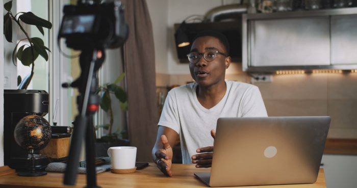 Professional at-home live stream set up with a man in front of camera and laptop.